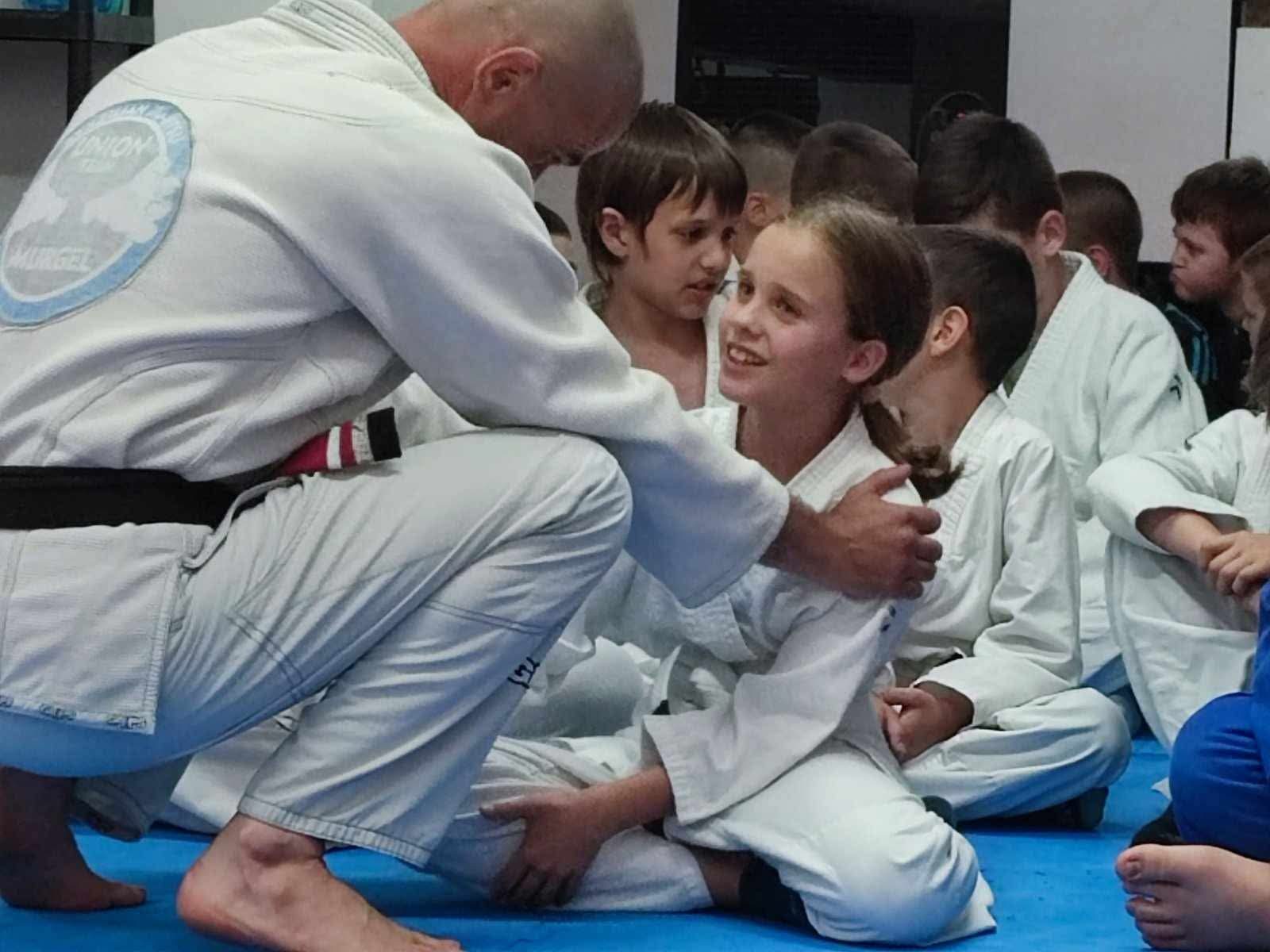 Trener razgovara s djecom na tatamiju